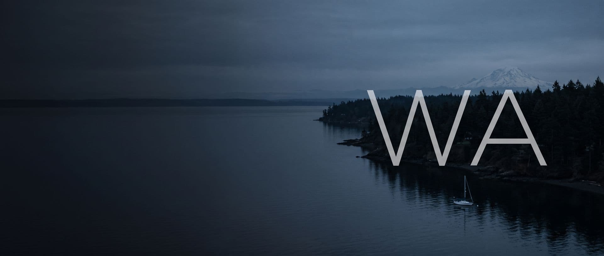 A forested Puget Sound shoreline with Mount Rainier beyond at dusk, a sailboat at anchor, with the letters WA in the sky