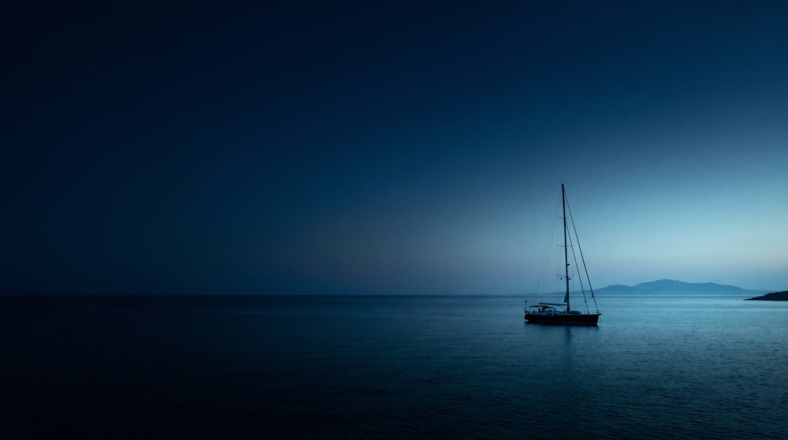 Sailing yacht at anchor in a sheltered Greek island cove in the Aegean evening light